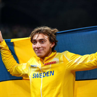 Armand Duplantis med svenska flaggan bakom ryggen.