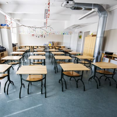 Klassrum med tomma pulpeter i en lågstadieskola. 