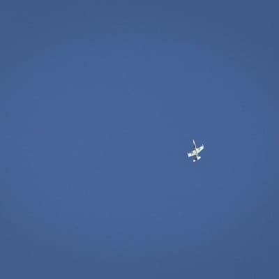 Ett syriskt stridsflygplan flyger över staden Fafeen i december 2012.
