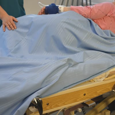 Vårdare brevid patientsäng