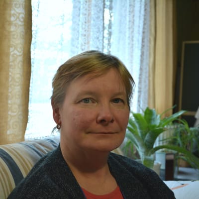 Profilbild på Outi Haanpää som sitter i en soffa. 