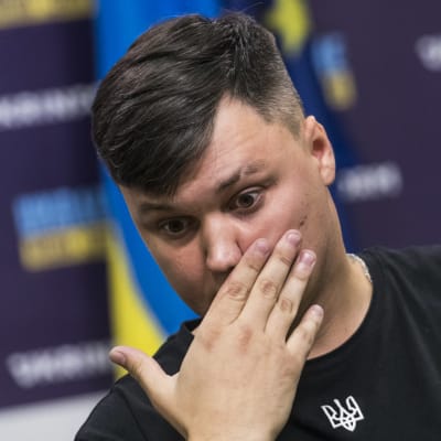 Maksim Kuzminov käsi suun edessä.