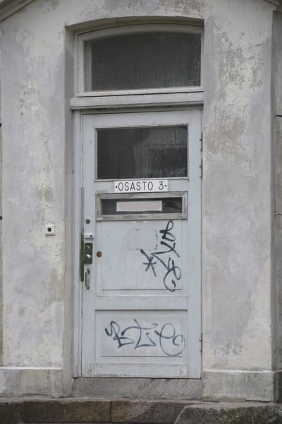 Sliten och nedklottrad dörr på vilken det står "Osasto 3" på en skylt.