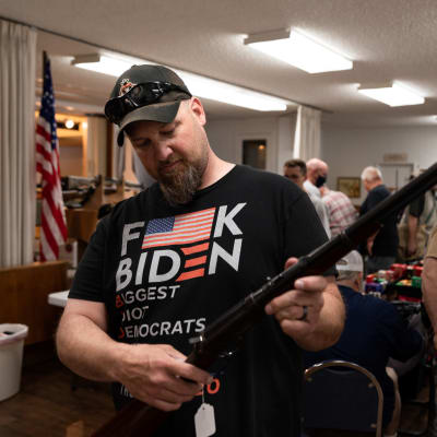 Brian McCluskey håller i ett gevär på en vapenmässa i Hamilton, Montana. Han gillar inte Joe Bidens planer på strängare federala vapenlagar.