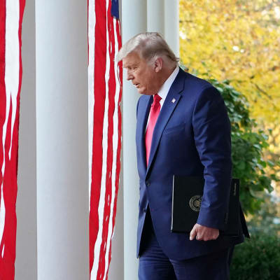 Donald Trump kävelee valkoisen talon edustalla
