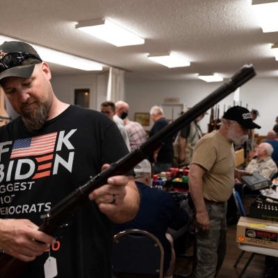 Brian McCluskey håller i ett gevär på en vapenmässa i Hamilton, Montana. Han gillar inte Joe Bidens planer på strängare federala vapenlagar.