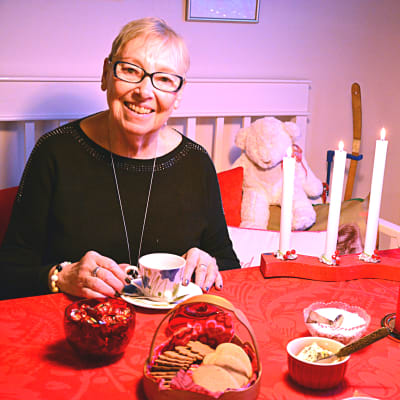 Ruth Lawast sitter vid dukat julkaffebord.