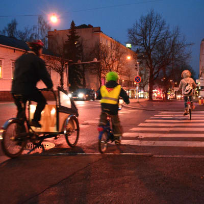 Tre cyklister på gatan