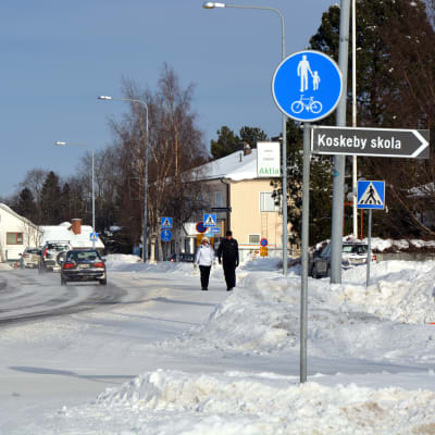 Vägen genom centrum av Vörå under vintern. På en skylt står det Koskeby skola.