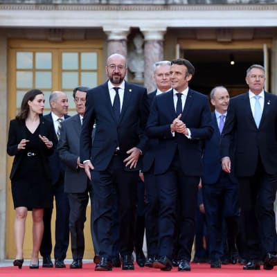 EU-ledare, bland dem statsminister Sanna Marin längst till vänster, går ut ur slottet i Versailles för att bli fotograferade tillsammans under mötet på Versailles 10-11 mars 2022.