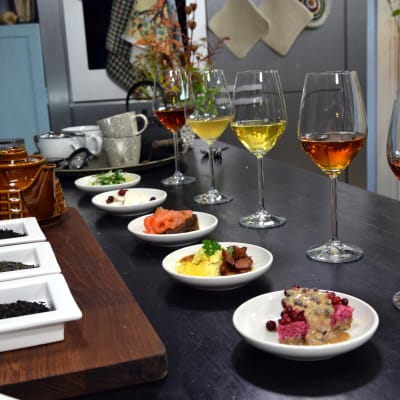 vinglas med olika teér och tallrikar med olika maträtter på ett bord