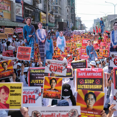 paljon mielenosoittajia, joilla on vallankaappausta vastustavia kylttejä ja Aung Saan Suu Kyin kuvia.