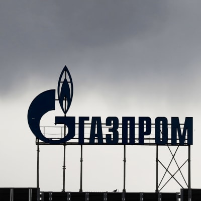 Gazpromin rakennus Pietarissa, tummia pilviä katolla olevan logon päällä.