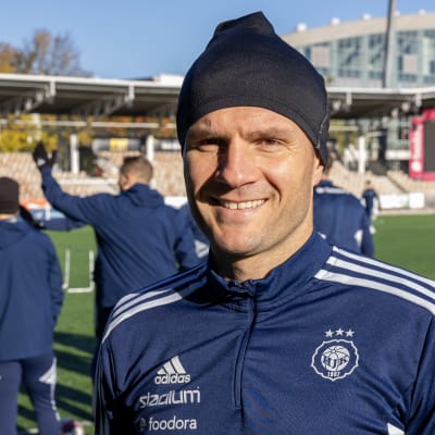 Perparim Hetemaj hymyilee kameralle treenivaatteet päällä kotikentällä.