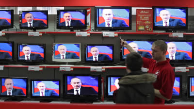 En elektronik affär i Ryssland med TV apparater som visar Vladimir Putin. 