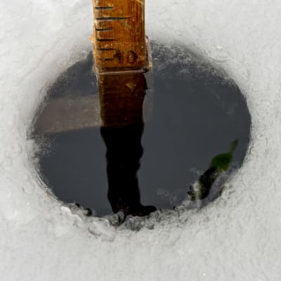 Jäänpaksuutta mitataan mittakepillä kairanreiästä.