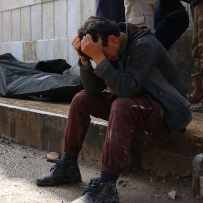 En syrisk man gråter intill tre liksäckar i rebellhållna Azaz, norra Syrien, efter ett bombdåd 3.5.2017