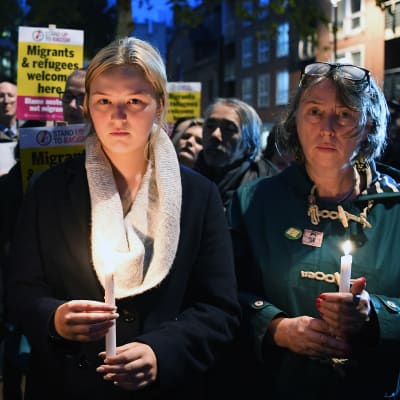 Personer håller i ljus och demonstrerar för flyktingar i London.