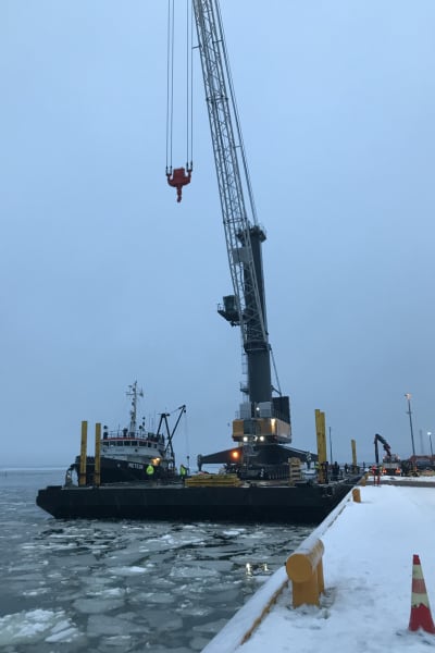Nya Liebherr-kranen flyttas över från pråmen till kajen i hamnen i Vasa.