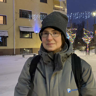 Pysäköinninvalvoja jouluvalaistulla kadulla.