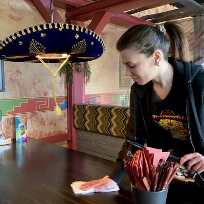 Lidiia Zaporozhets pyyhkii pöytiä Kalevan Pancho Villa -ravintolassa.