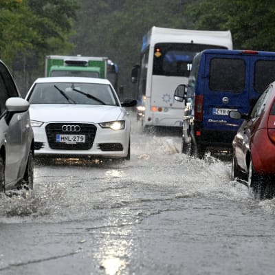 Tät trafik på översvämmad gata.