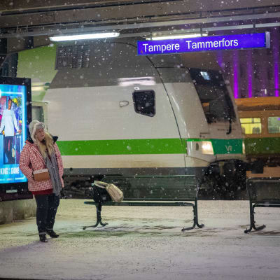 Nainen odottelee junaa Tampereen juna-asemalla.