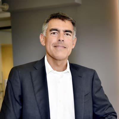 Mikko Ayub i vit skjorta och mörkgrå kostym. 