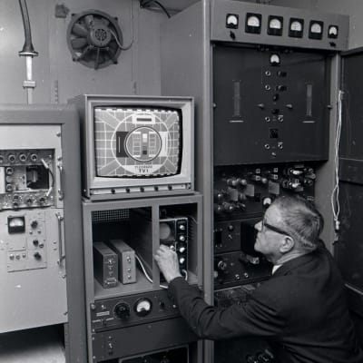 En man justerar radio- och teveteknik.