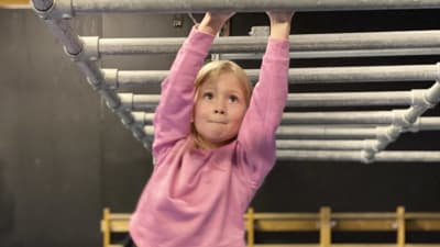 Sexåriga Engla Kajander svingar sig mellan ribbor i luften.