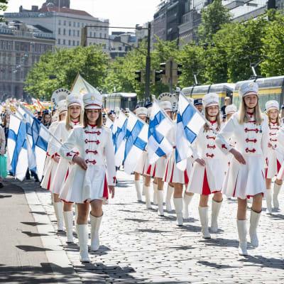 Nuoria naisia marssii valkoisissa uniformuissa Mannerheimintiellä.