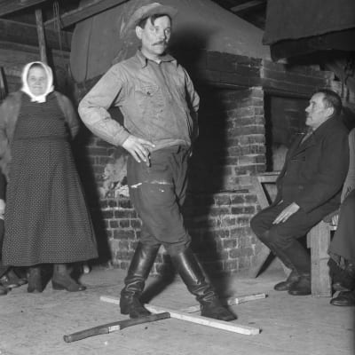 En man leker "gå på tiljan", där man ska bevisa att man inte är berusad. Bilden är tagen 1937 i Bromarf, Rilaks.