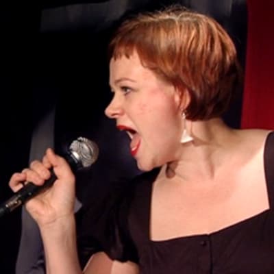 Paula Lehtomäki laulaa karaokea.