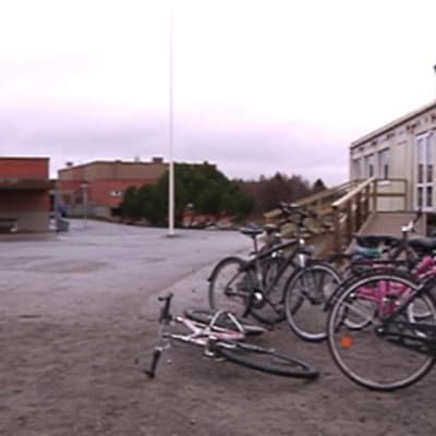 Kuvassa Isokylän koulun pihapiiri, oikealla parakkikoulu ja taustalla päärakennus, etualalla polkupyöriä