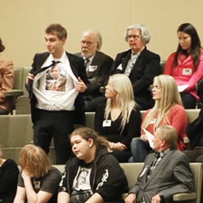 Henkilö häiriköi eduskunnan istunnossa avaamalla paitansa torstaina 17. marraskuuta 2011.