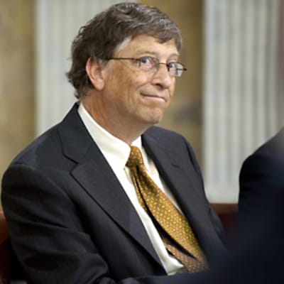 Bill Gates hymyilee kahden etualalla olevan epäselvän ihmishahmon välistä.