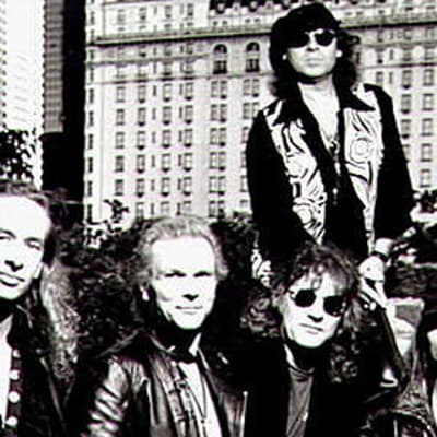 The Scorpions -yhtyeen jäsenet Ralph Rieckermann, Rudolf Schenker, Herman Rarebell, Klaus Meine ja Matthias Jabs ulkona kaupunkimaisemassa auringonpaisteessa. Mustavalkokuva.