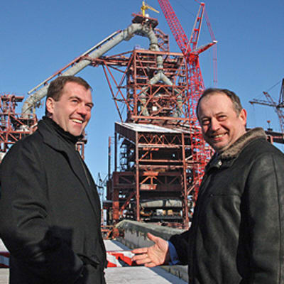 Venäjän presidentti Dmitri Medvedelisin ja Novolipetsmetallin pääjohtaja Vladimir Lisin hymyilevät vierekkäin Novolipetsmetallin tehtaan edessä.