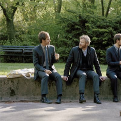 The National yhtyeen jäsenet istuvat puistossa.
