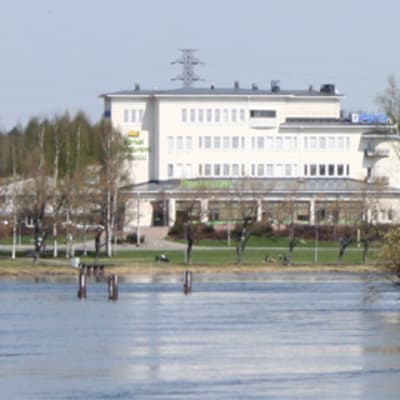 Pohjois-Karjalan osuuskaupan valkea päärakennus Pielisjoen rannalla.