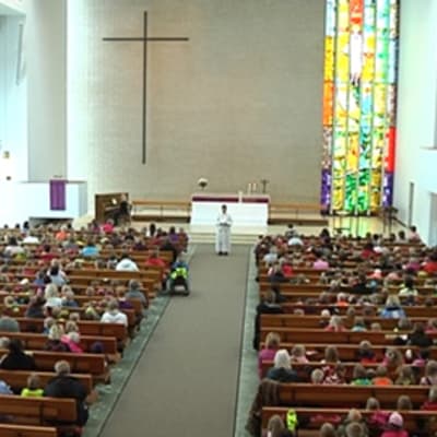Kuvassa satoja päiväkoti-ikäisiä lapsia istumassa Kokkolan kirkossa.
