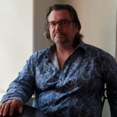 Kriitikko esseisti journalisti Putte Wilhelmsson istuu Cafe Artessa.