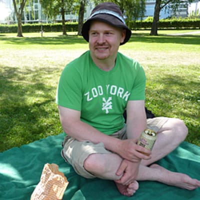Matti Huhta istuu viltillä puistossa.