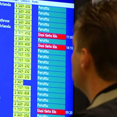 Mies katselee peruttujen lentojen listaa Helsinki-Vantaalla