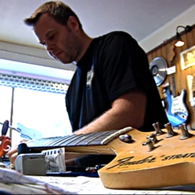 Kitarapajan kitaraspesialisti Jaakko Kiikeri huoltaa kitaraa.