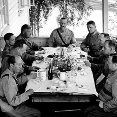 Eversti Aaro Pajarin tarjosi lounaan pappilan verannalla. Pöytäseurueessa oli armeijakunnan johtoa ja muita upseereita Mannerheimin ohella. Seinällä nojailee piika.