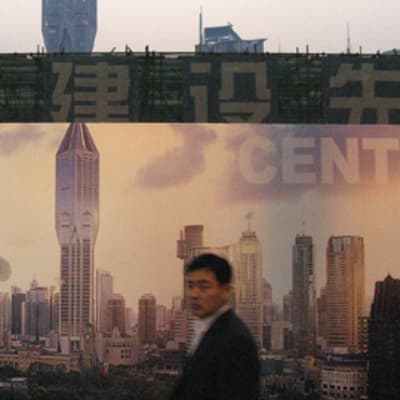 Ihmisiä Shanghain tulevaisuuden kaupunkiprofiilia esittävän mainoksen edessä.