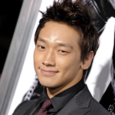 Etelä-korealainen laulaja Rain hymyilee kameralle, taustalla on hänen tähdittämänsä Ninja Assassin -elokuvan mainoshahmo.