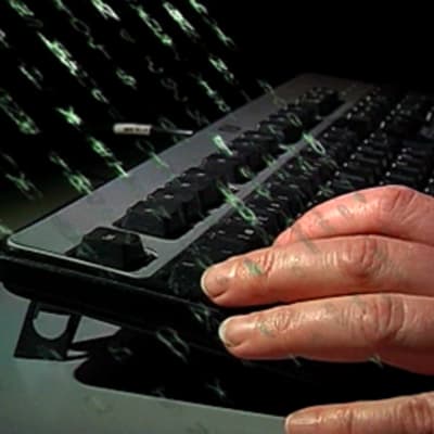 Miehen kädet tietokoneen näppäimistöllä