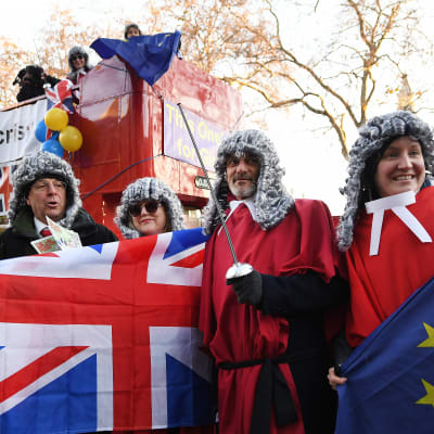 Demonstranter klädda i domarperuker håller upp EU:s och Storbritanniens flagga.